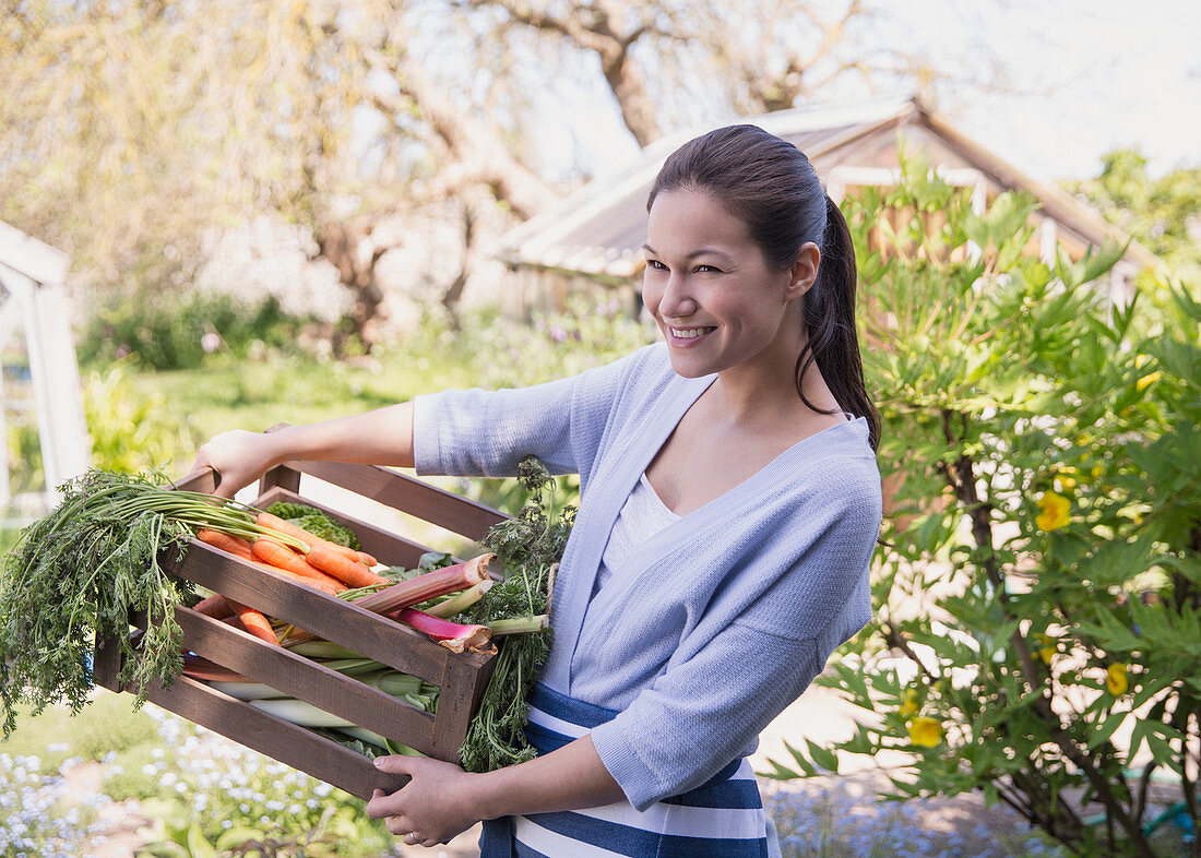 Woman holding fresh harvested vegetables
