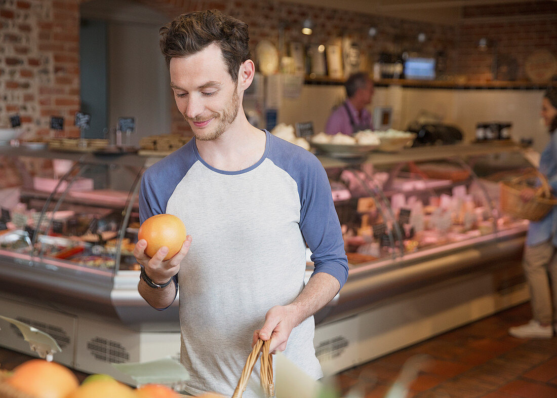 Man examining grapefruit in market