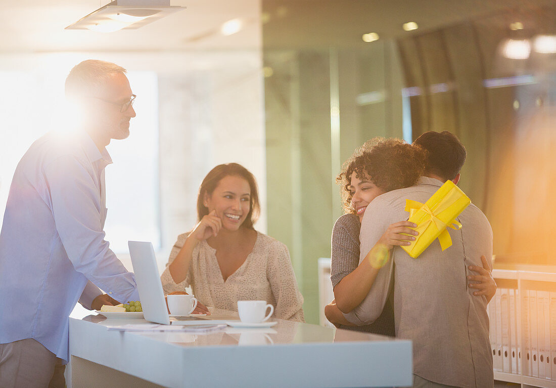 Businessmen giving gift to businesswoman