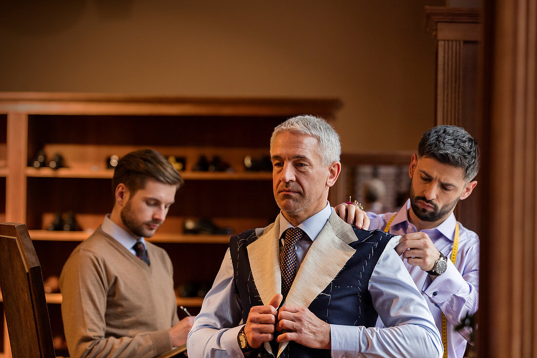 Tailors fitting businessman for suit