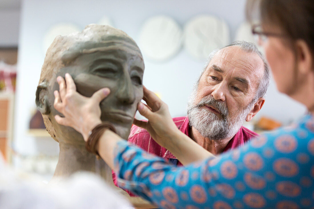 Woman sculpting clay face