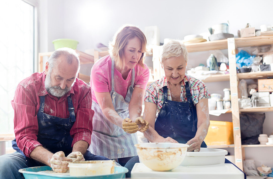 Senior couple using pottery wheels