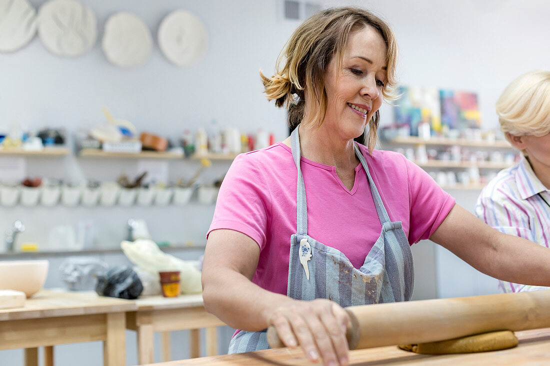 Mature woman rolling clay