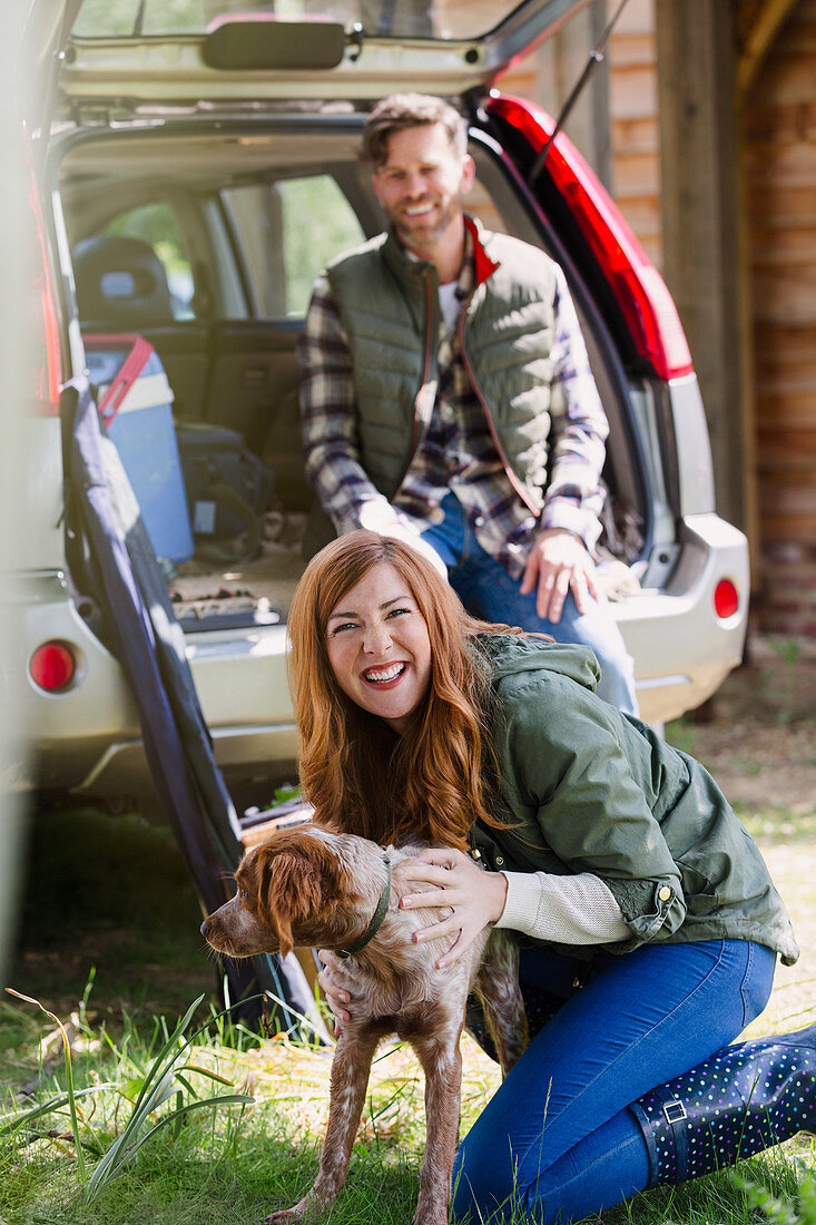 Woman with dog outside car