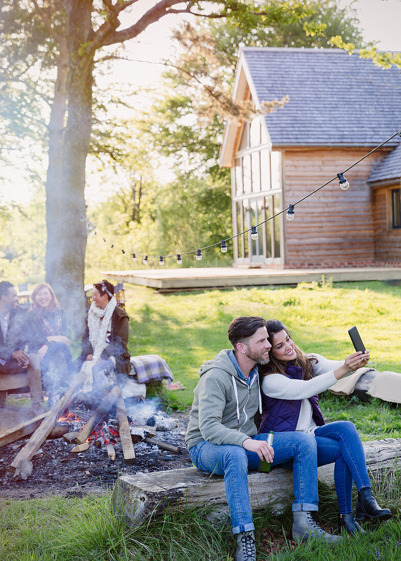 Couple taking selfie at campfire