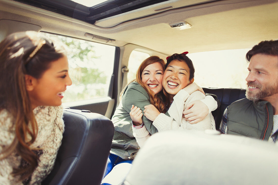 Female friends hugging in car