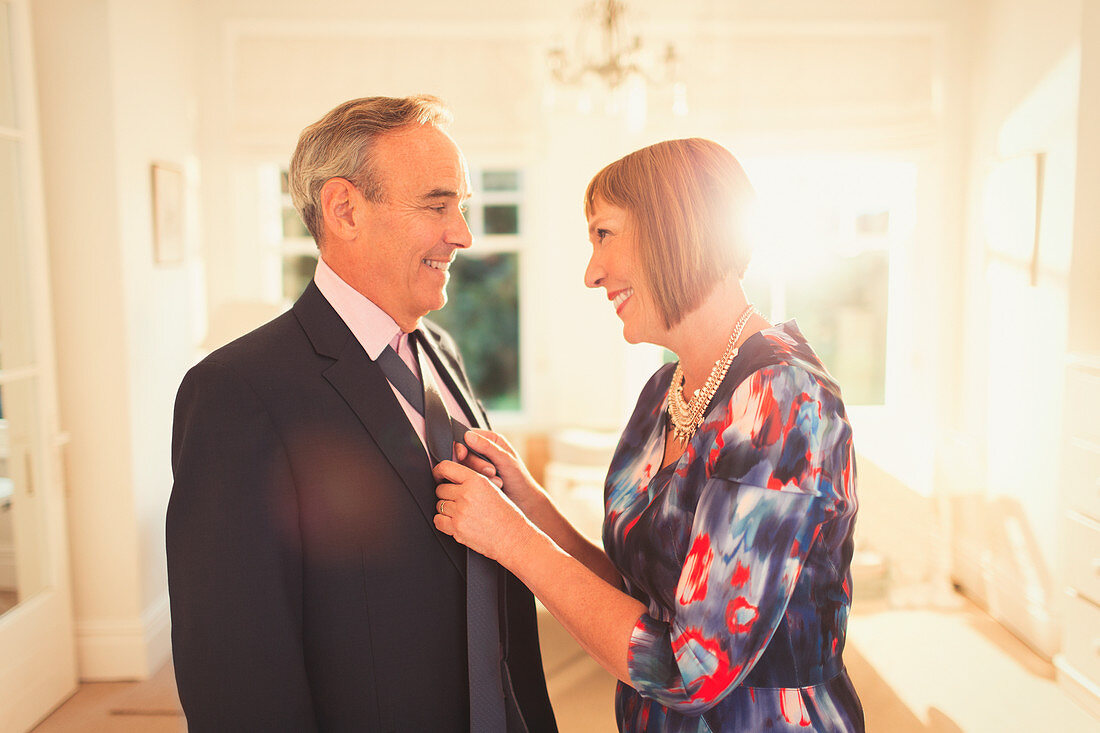 Smiling wife tying husband's tie