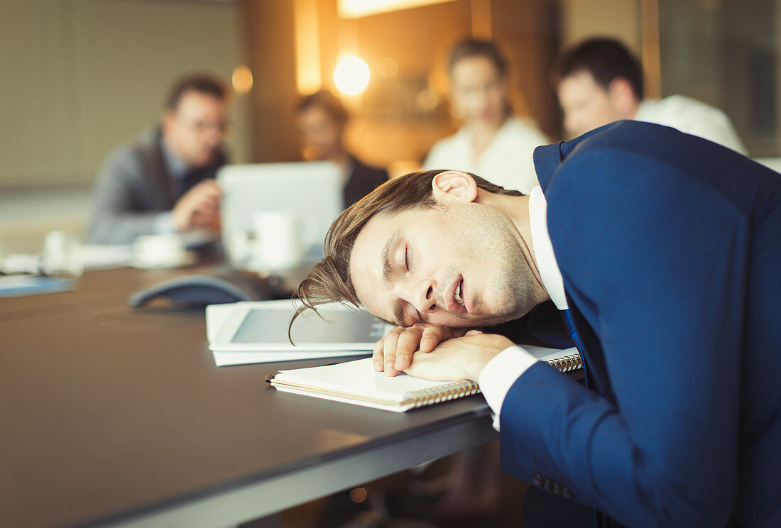 Businessman sleeping in conference room meeting
