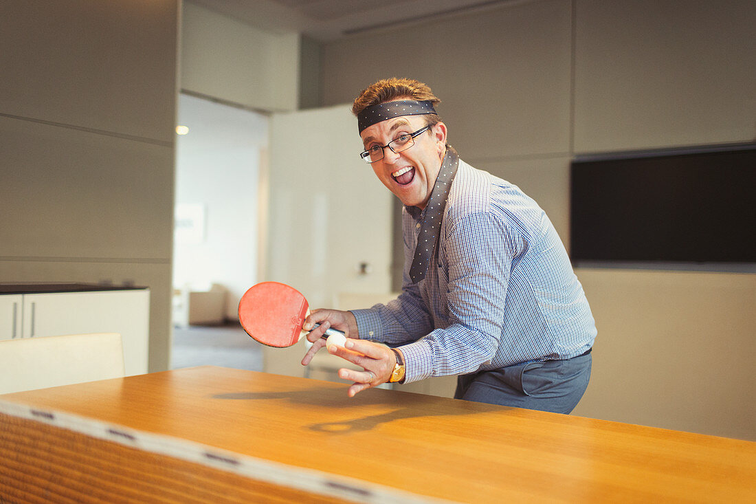 Businessman playing ping pong in conference room