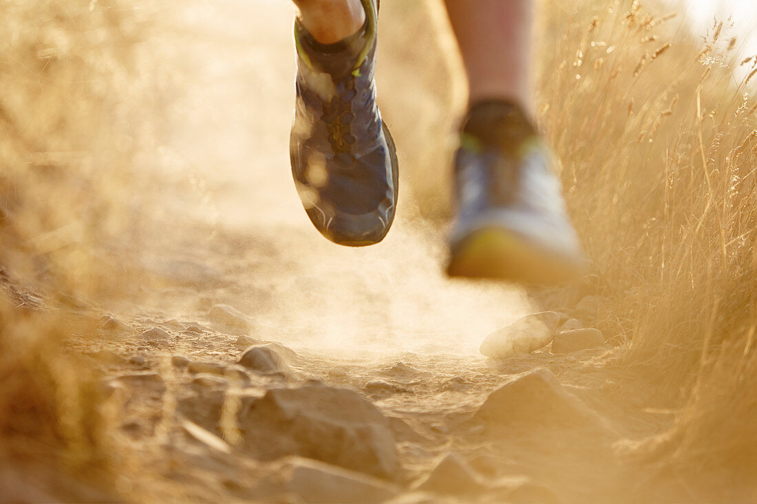 Close up of runner's feet on dirt trail