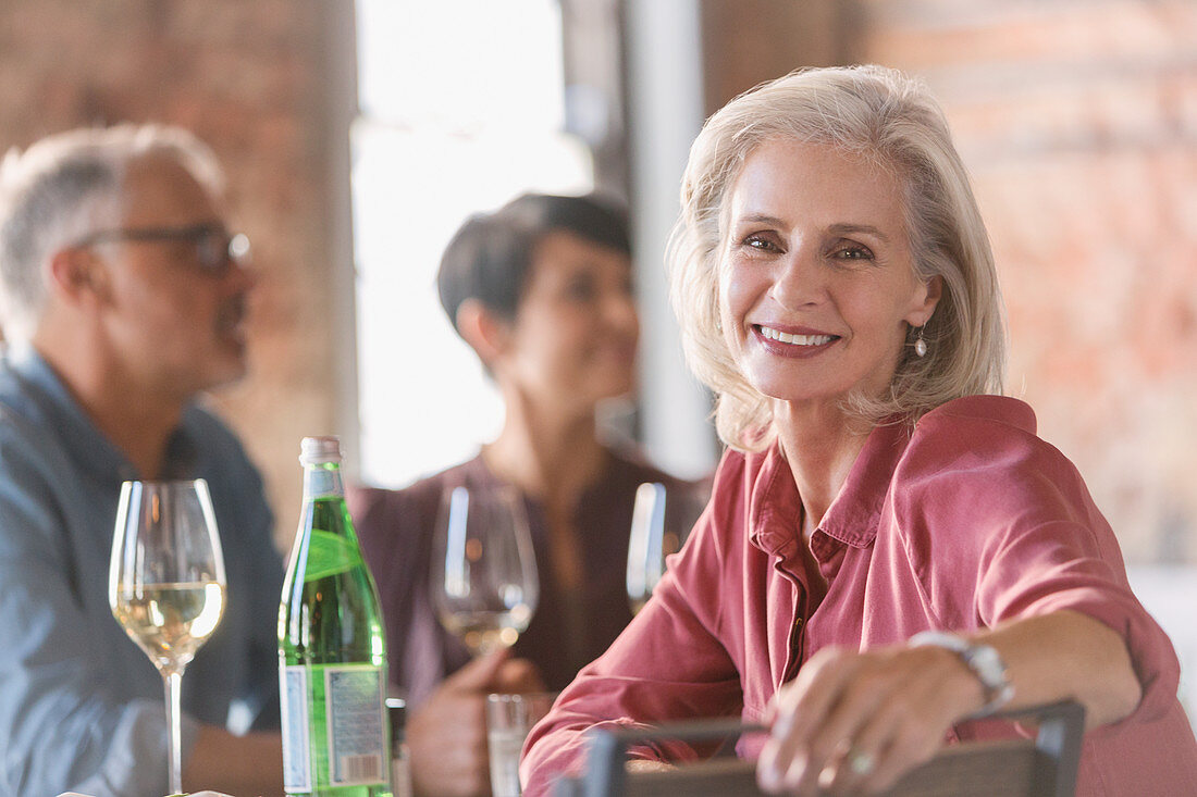Portrait smiling senior woman dining with friends