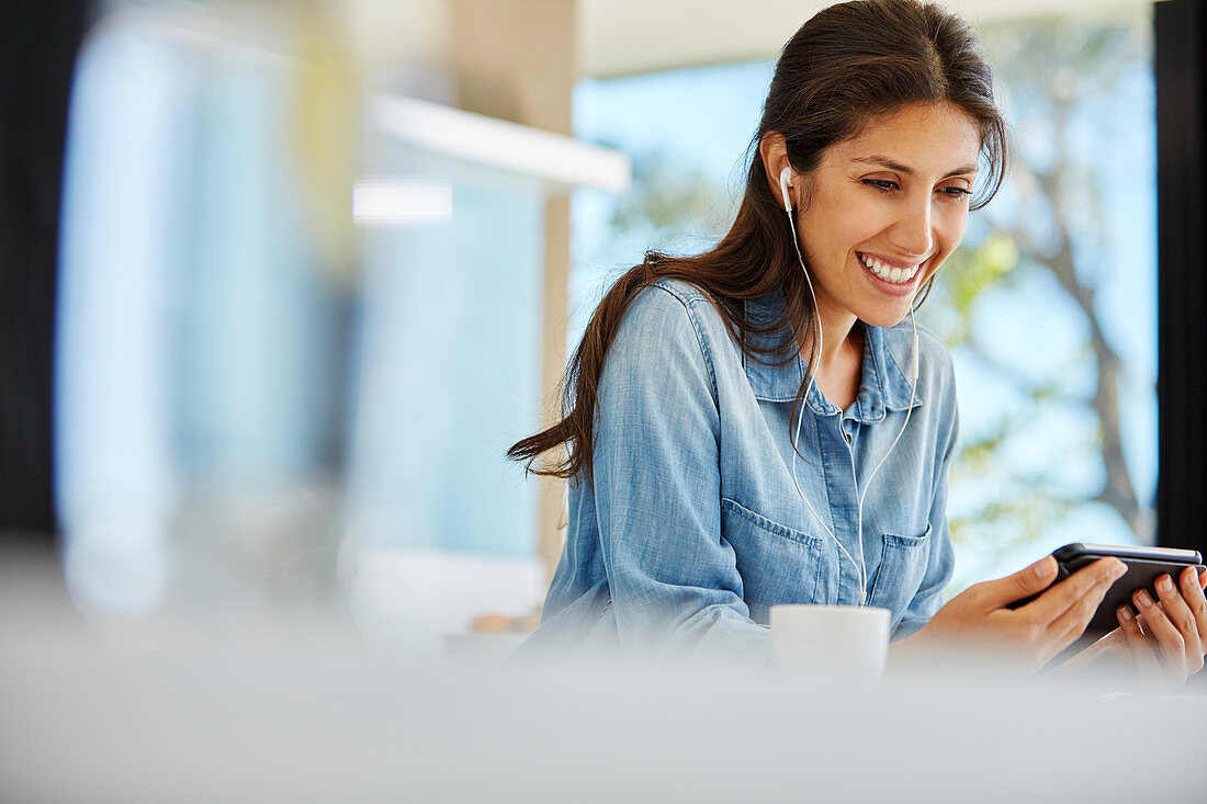 Smiling woman using digital tablet and headphones