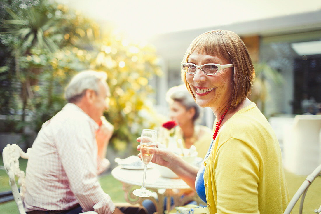 Portrait Woman drinking champagne at garden party