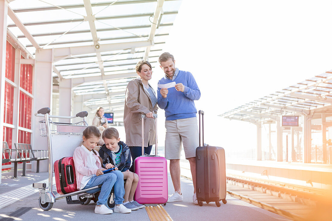 Family with suitcases waiting platform