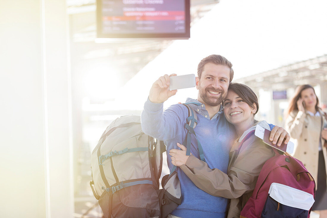 Couple with backpacks taking selfie