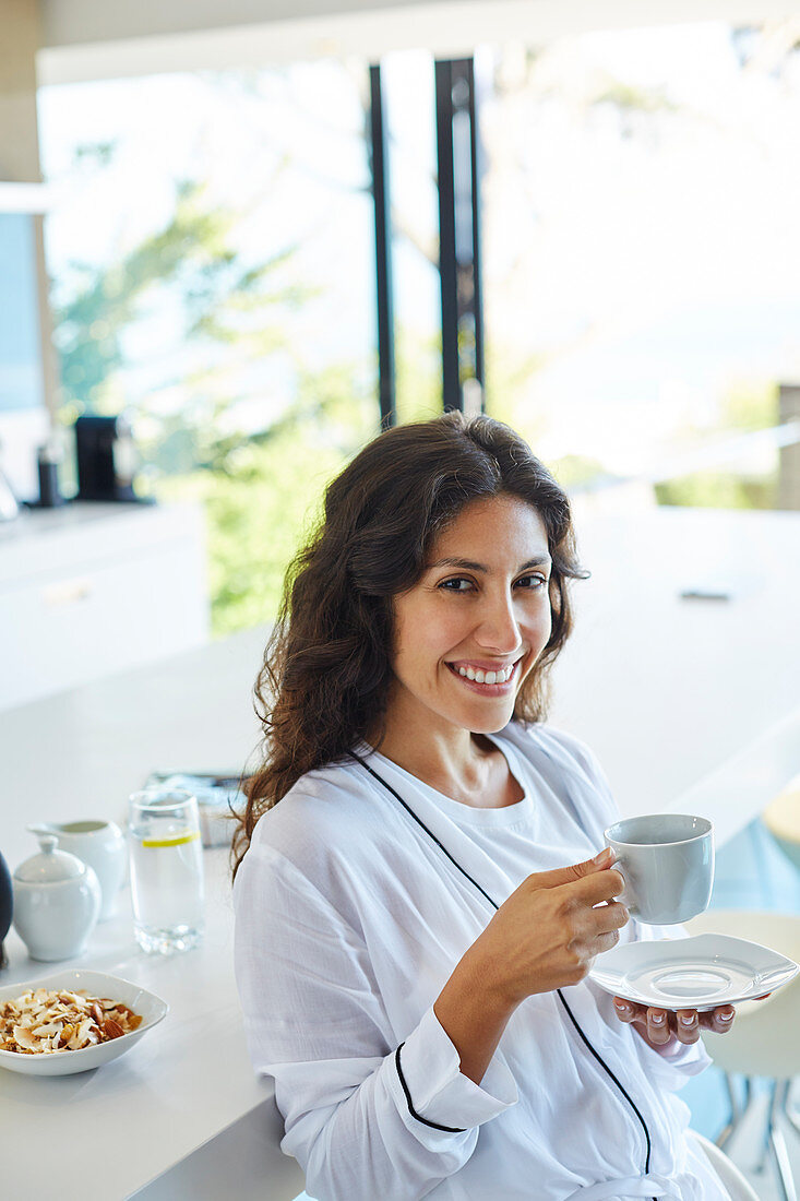 Portrait smiling woman in bathrobe drinking coffee