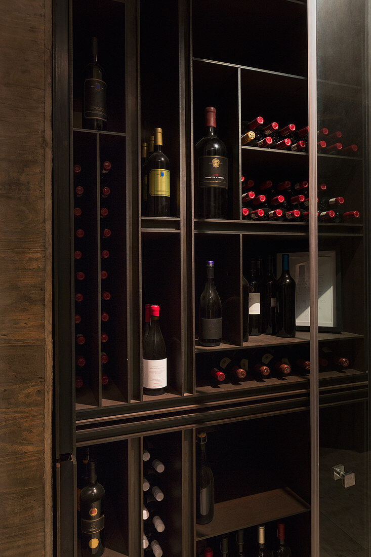 Wine bottles organized on wooden shelves