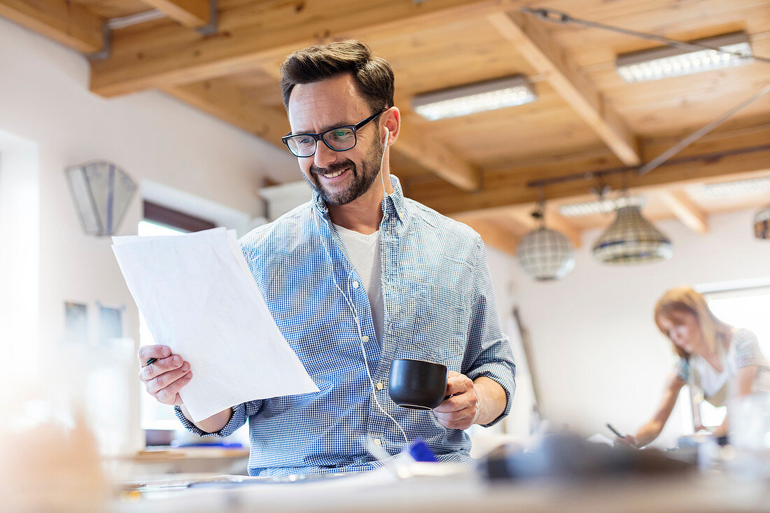 Smiling artist reviewing drawings