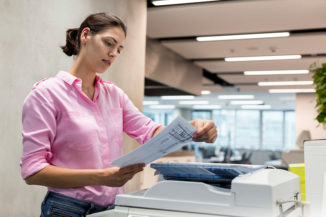 Businesswoman using photocopier in office