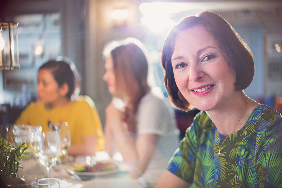 Portrait smiling woman dining with friends
