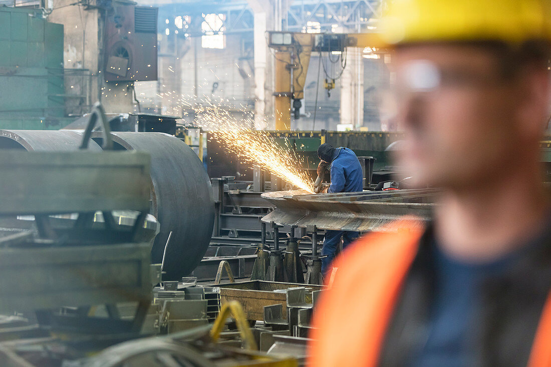 Welder using welding torch in steel factory