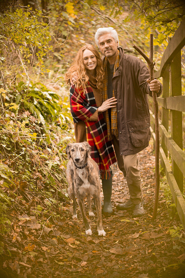 Portrait smiling couple with dog and walking stick