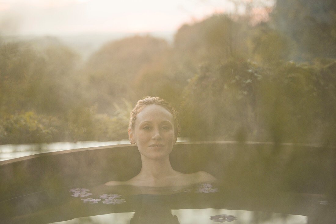 Portrait serene woman soaking in hot tub