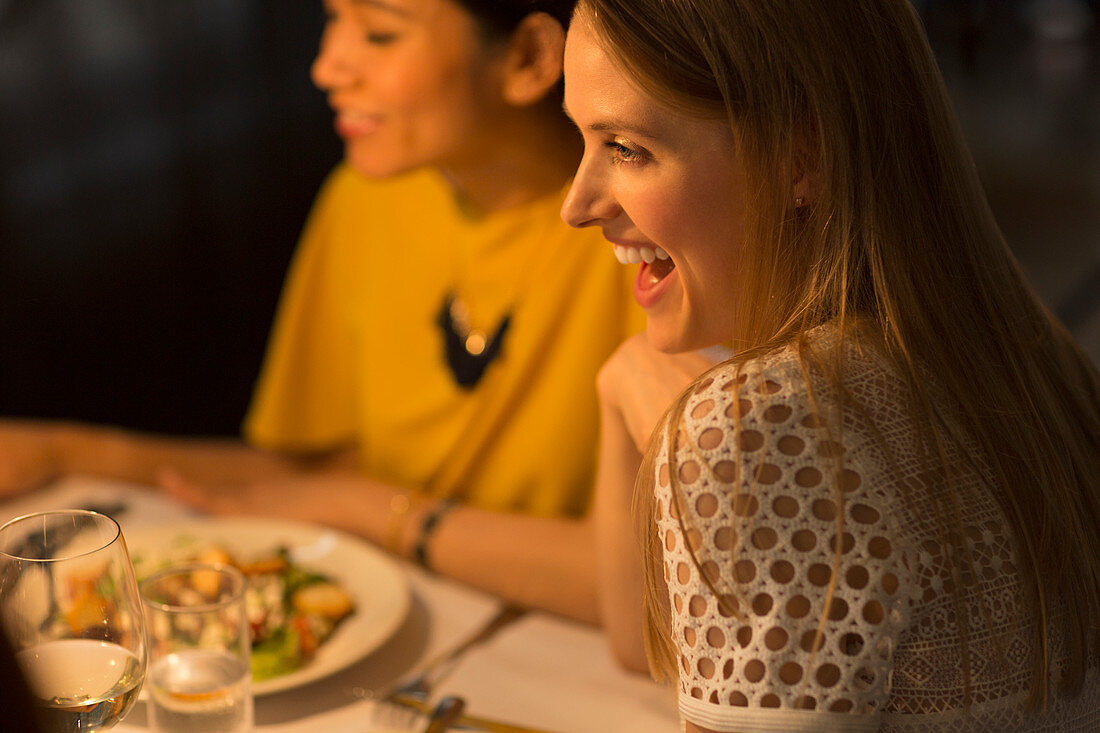 Smiling woman dining with friends