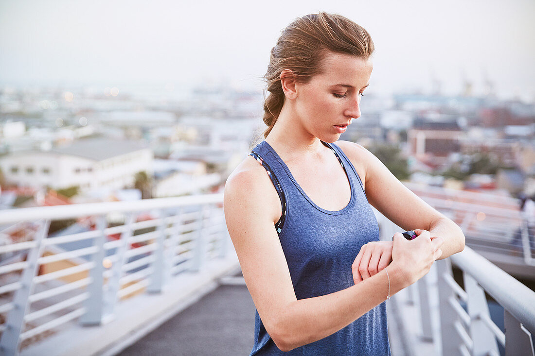 Female runner checking smart watch fitness tracker