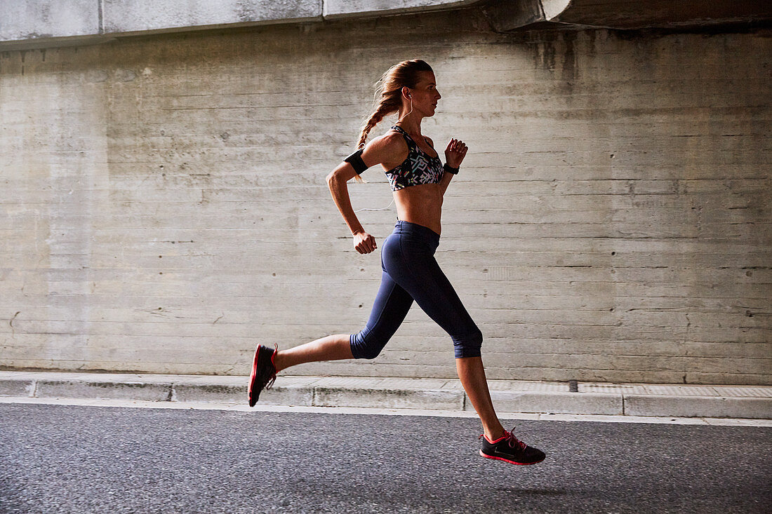 Female runner running on urban street