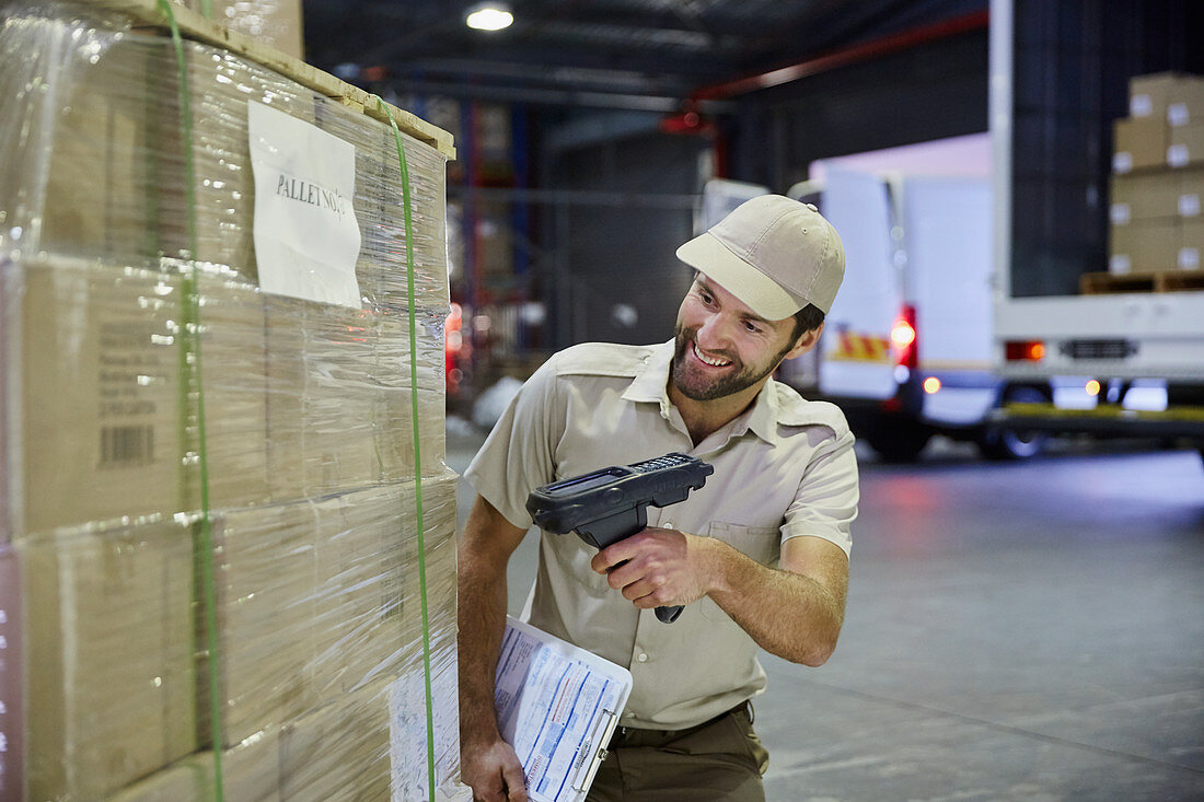Truck driver worker scanning pallet of boxes