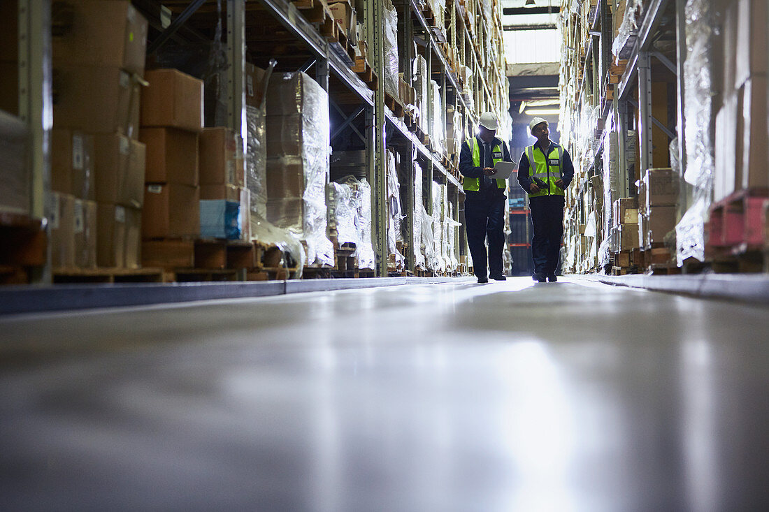 Workers walking in distribution warehouse aisle