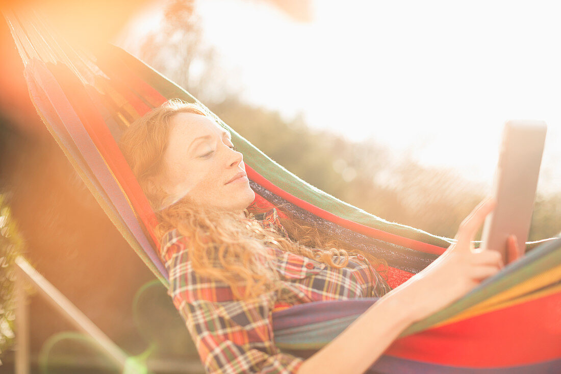 Woman relaxing in sunny hammock