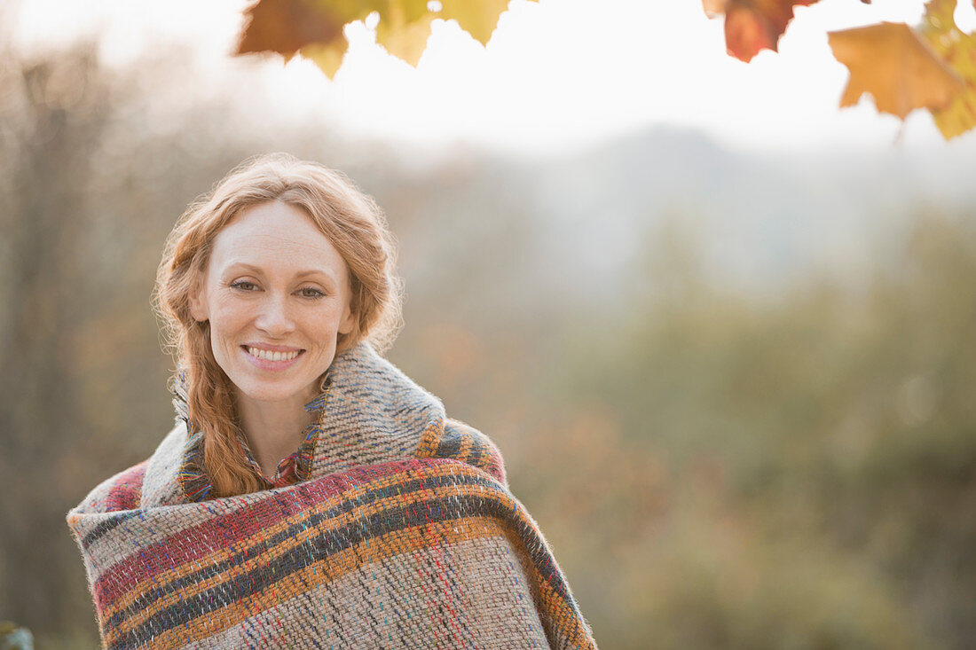 Portrait smiling woman wrapped in blanket
