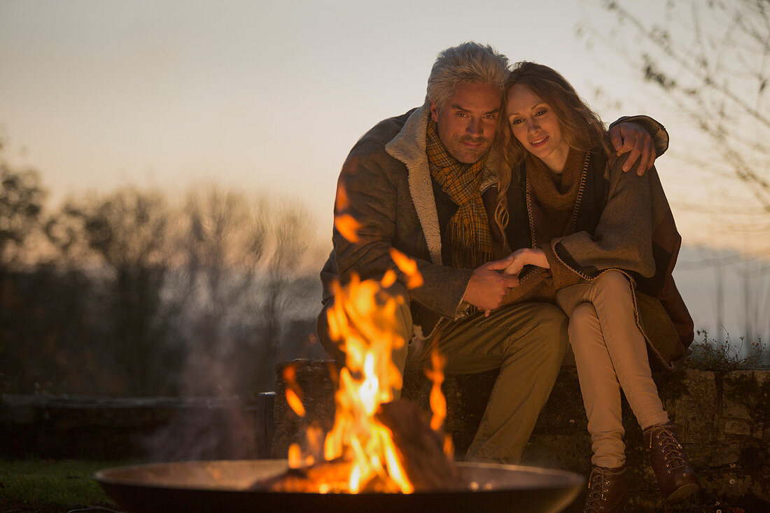 Serene couple enjoying autumn campfire