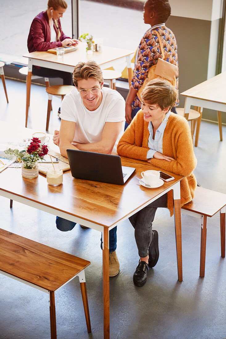 Business people drinking coffee working at laptop