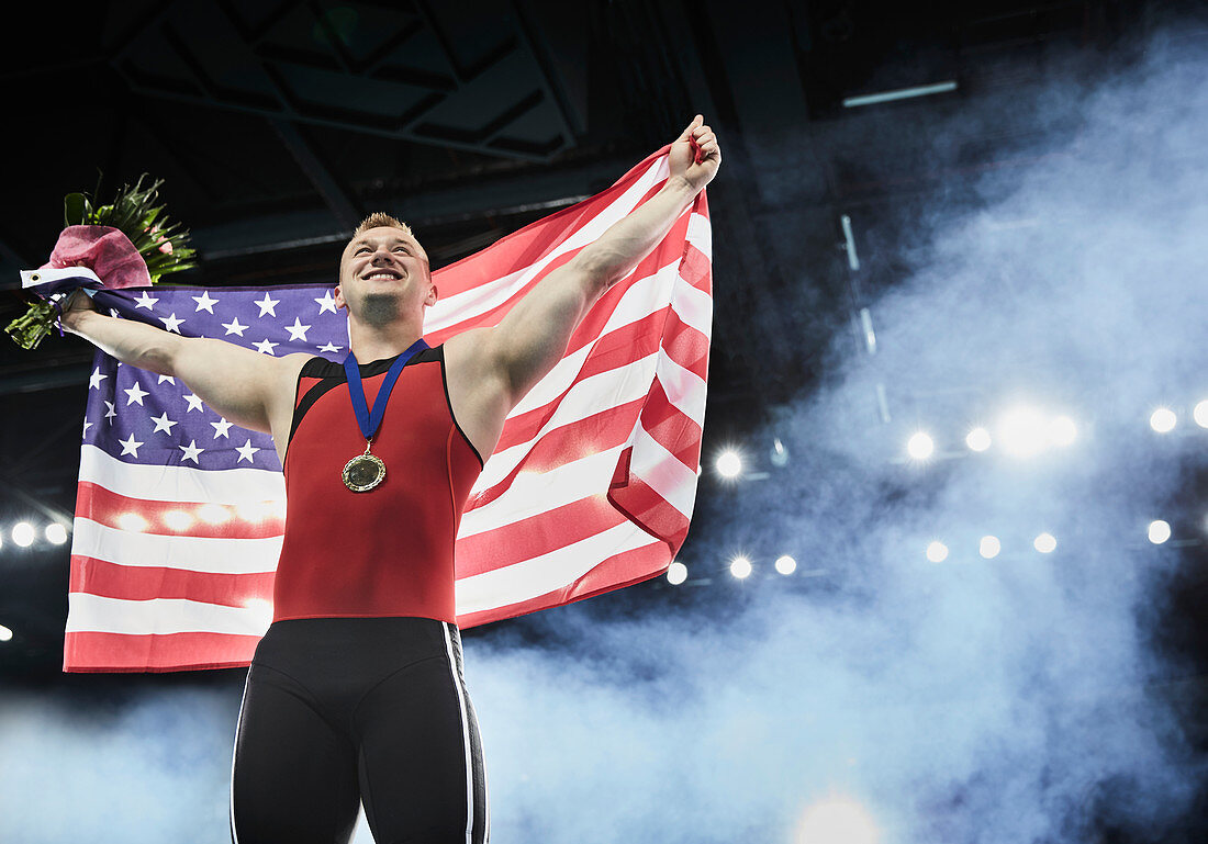 Male gymnast holding American flag