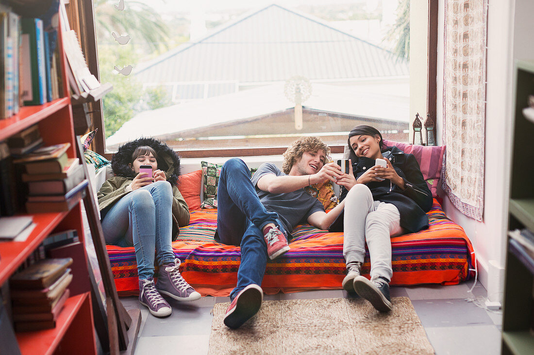 Young friends hanging out using cell phones