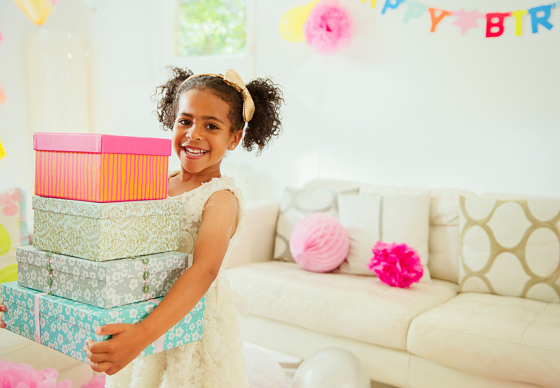 Girl carrying stack of birthday gifts