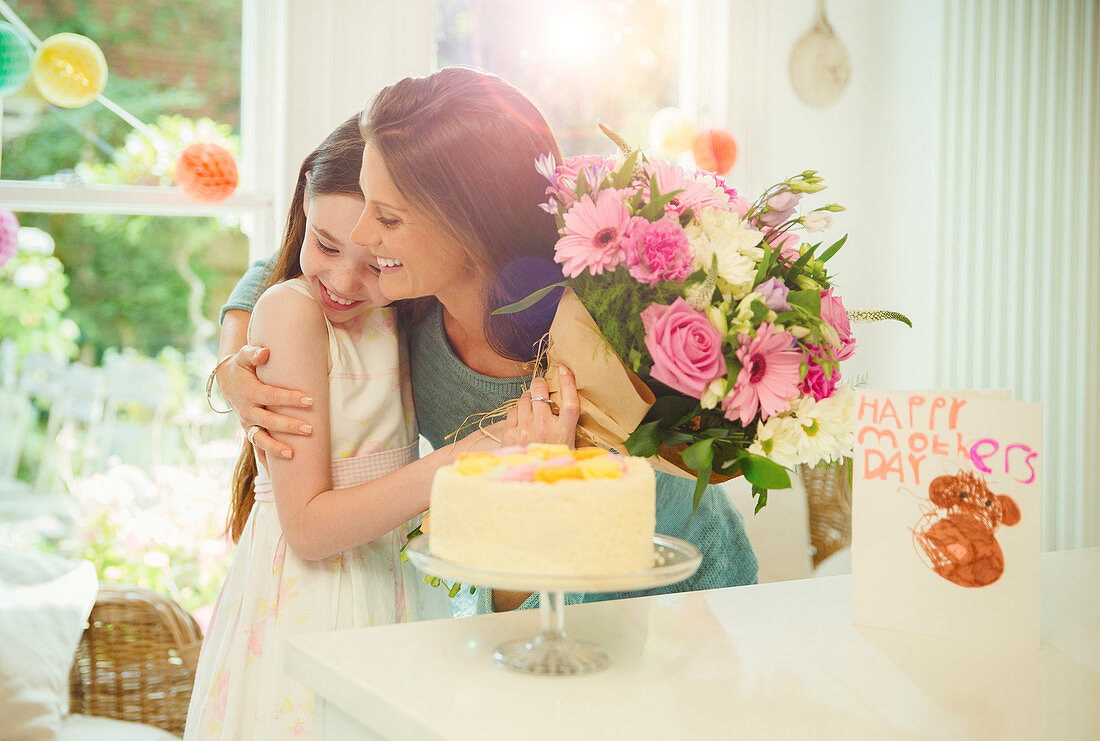 Daughter giving flower bouquet to mother
