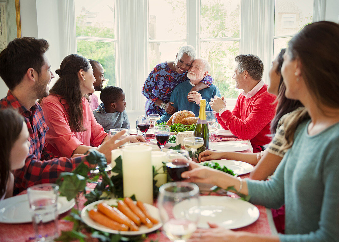 Senior couple hugging at family Christmas dinner