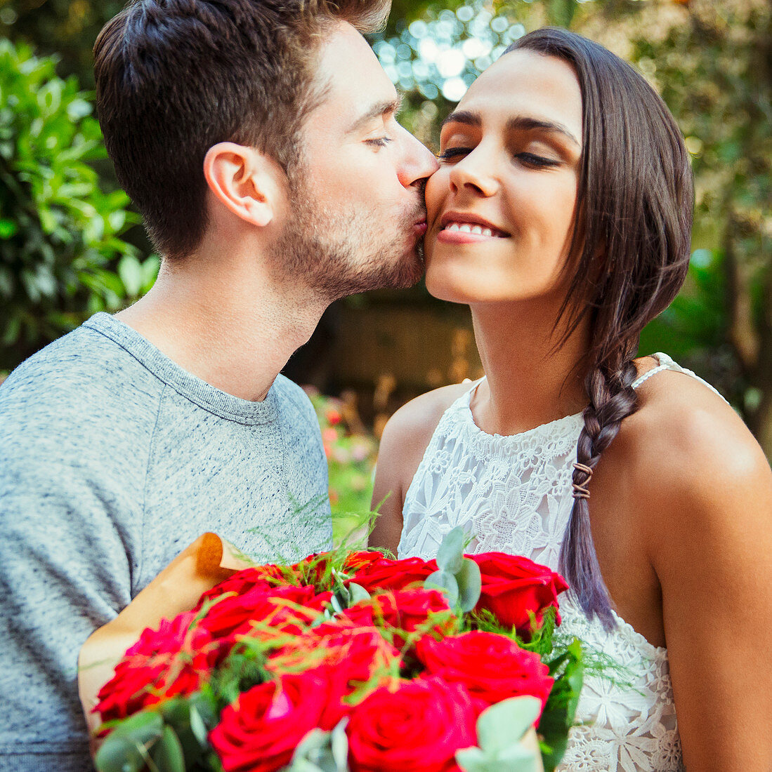 Man giving red rose bouquet to girlfriend