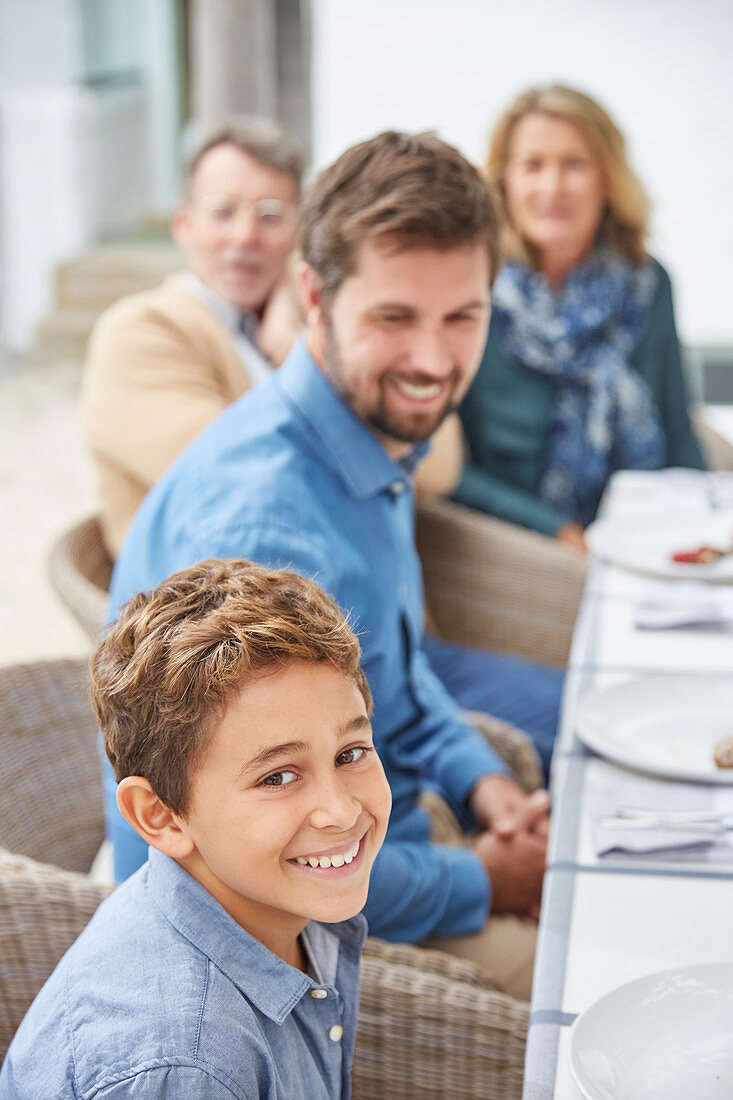 Portrait smiling boy enjoying lunch with family