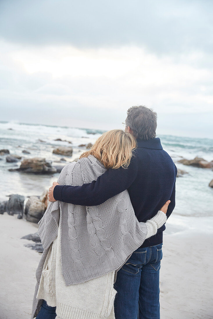 Couple hugging on winter beach