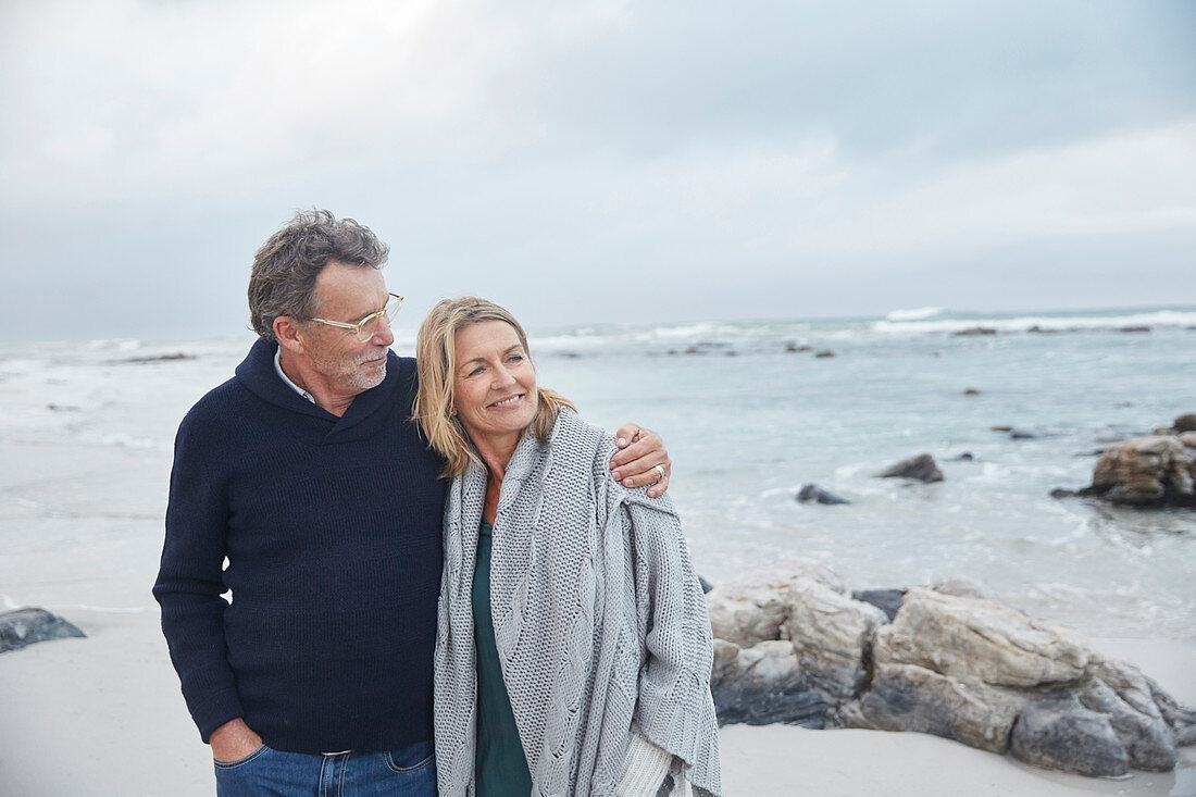 Affectionate couple hugging on winter beach