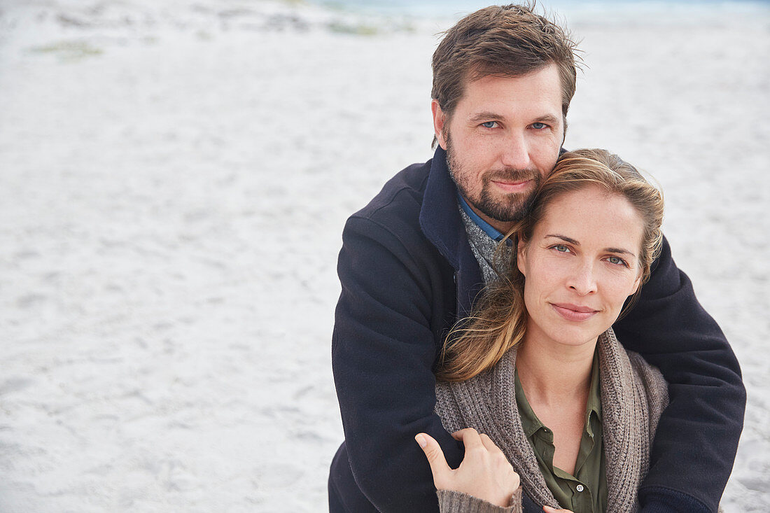 Portrait serene couple hugging on beach