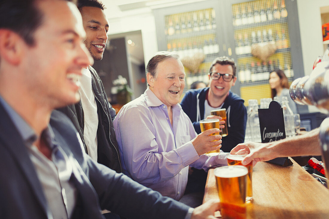 Men friends drinking beer at bar