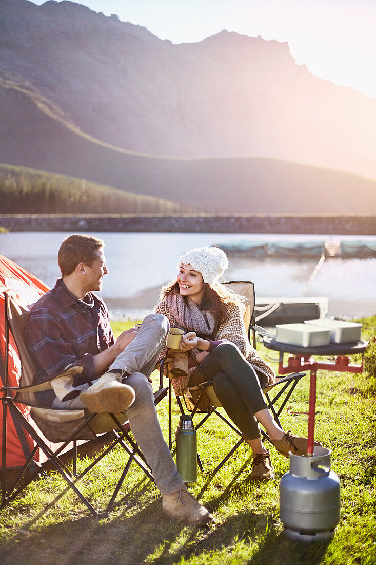 Young couple camping, drinking coffee