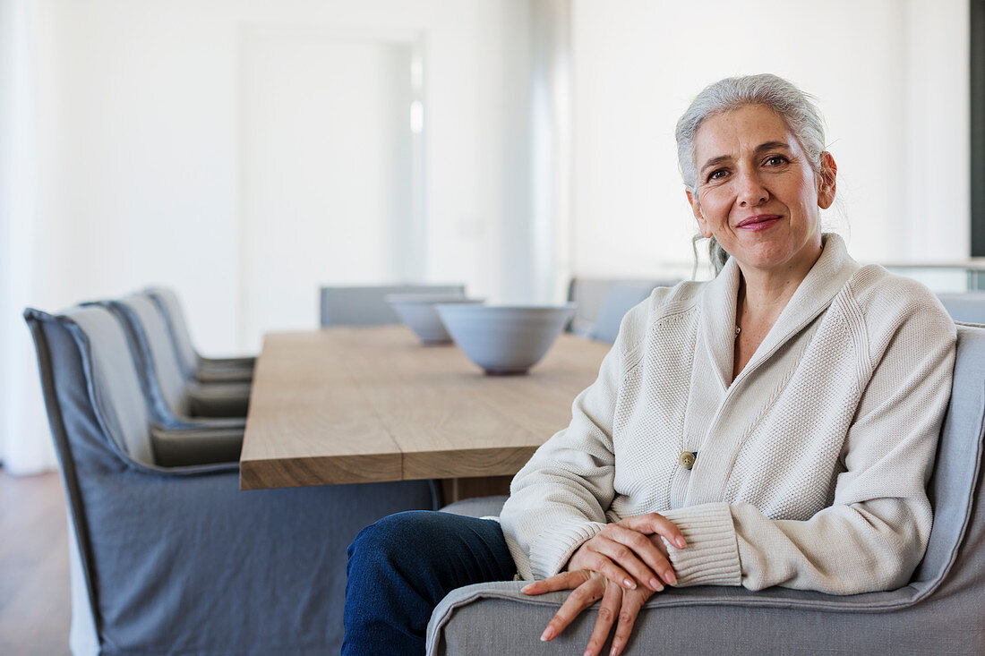 Portrait mature woman sitting at dining table
