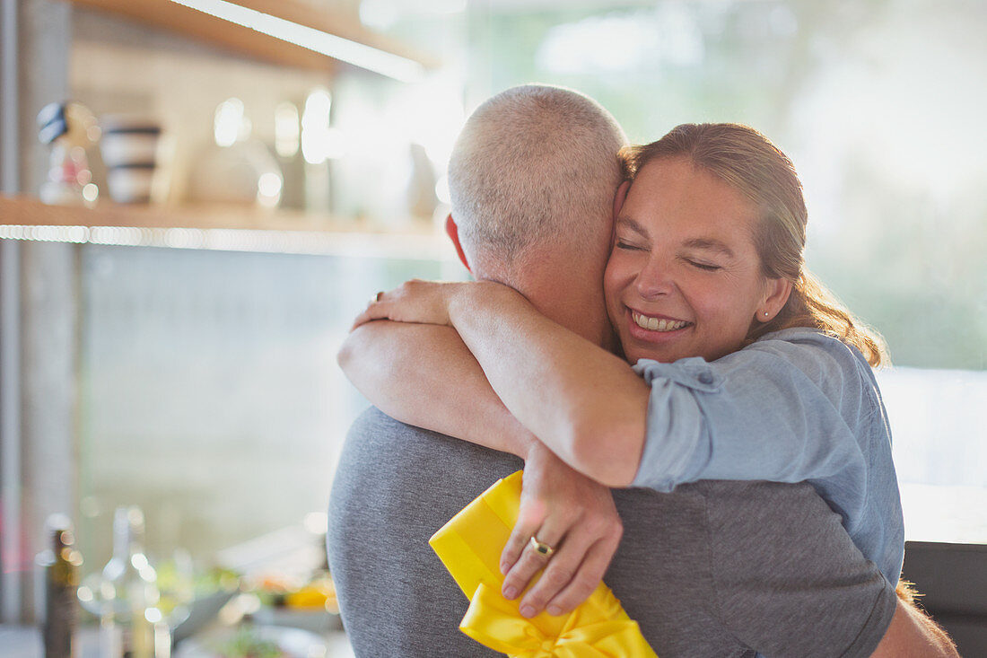 Happy couple hugging in kitchen